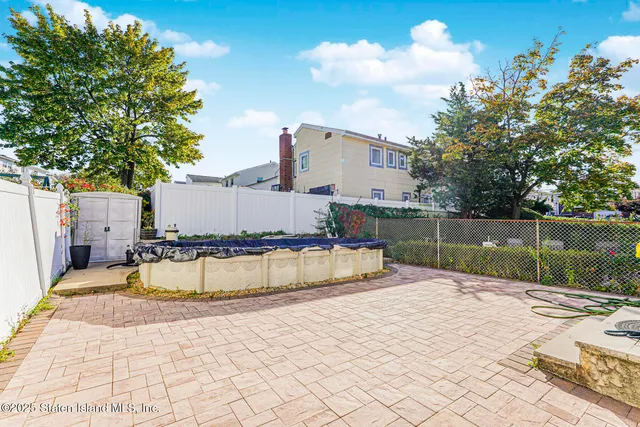 a swimming pool with a yard and wooden fence