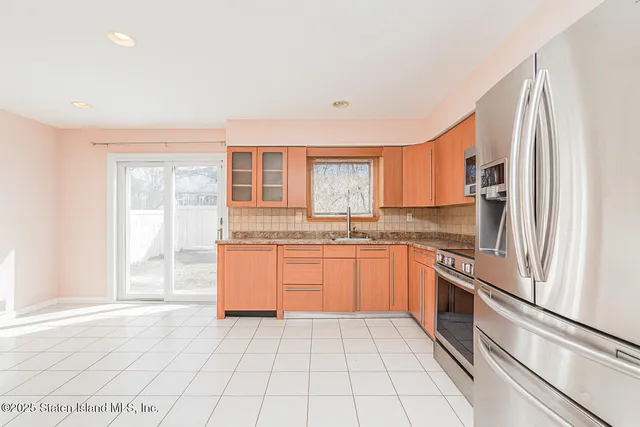 a kitchen with stainless steel appliances granite countertop a refrigerator and a sink