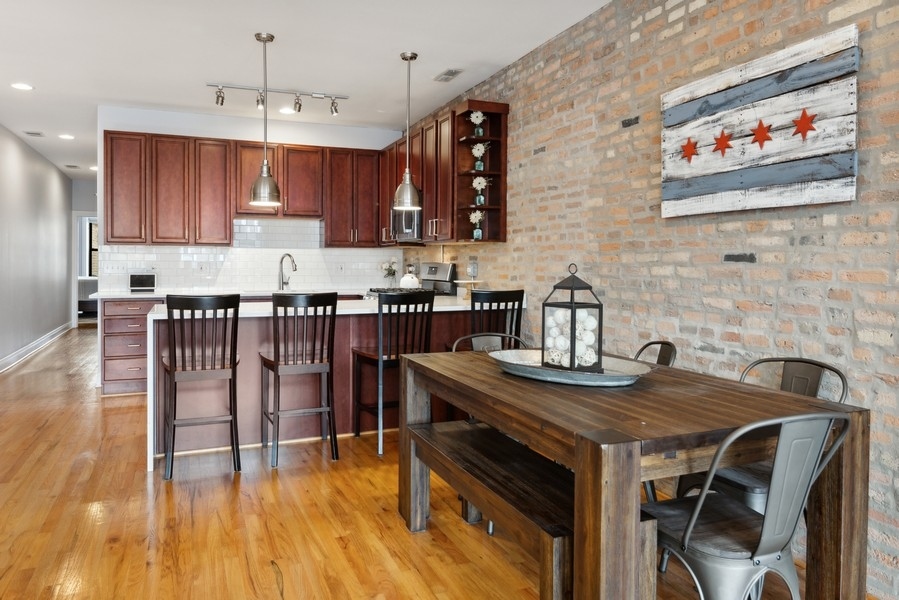 1025 West Madison Street, Unit 4 Chicago, IL 60607 - Photo 11 of 26 a kitchen with a table chairs stove and cabinets