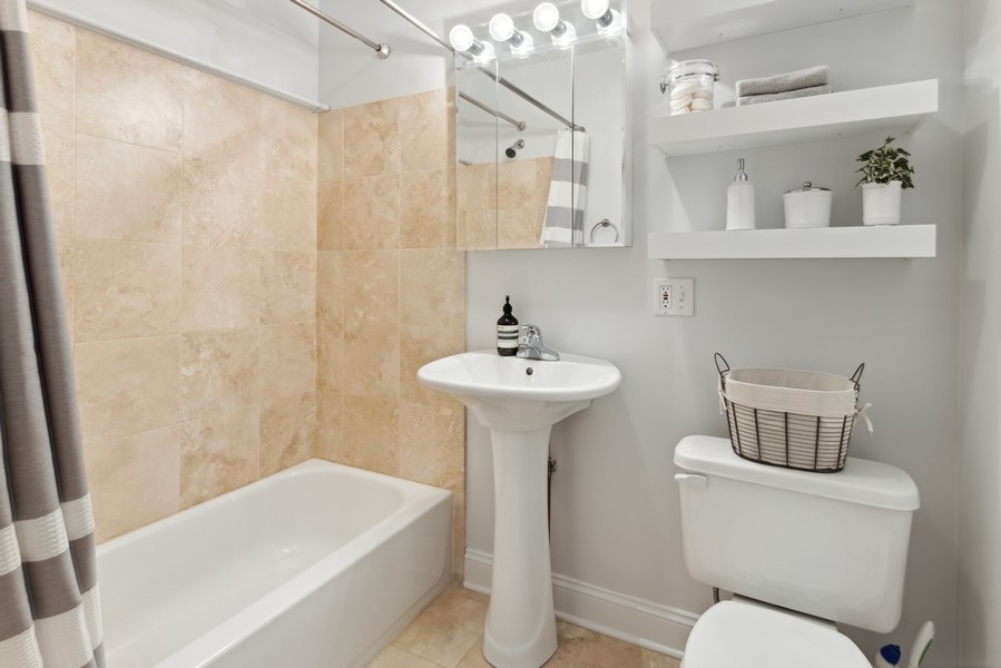 1025 West Madison Street, Unit 4 Chicago, IL 60607 - Photo 20 of 26 a bathroom with a sink a toilet and shower