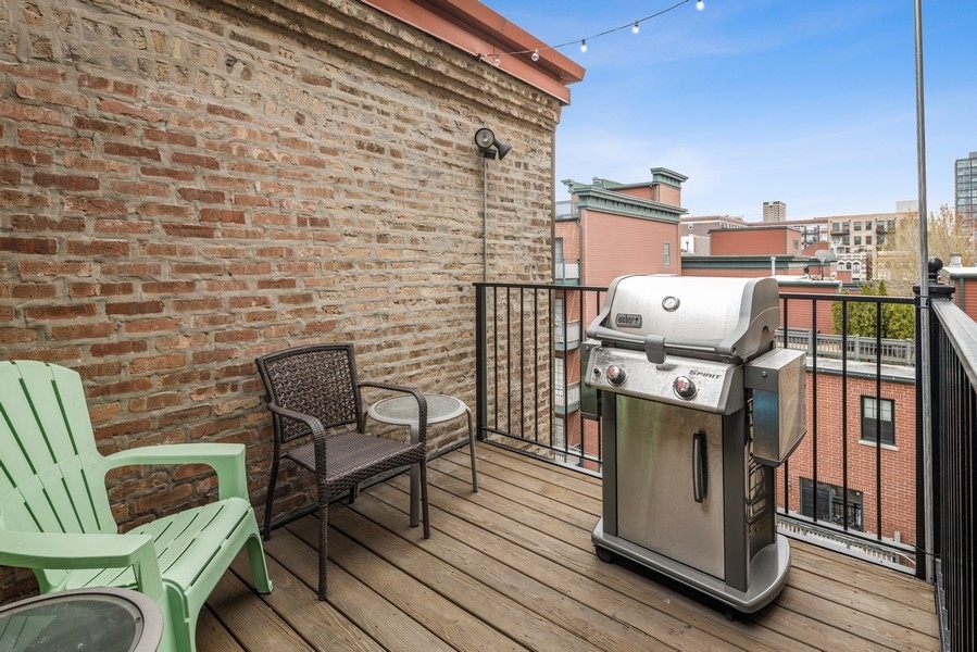 1025 West Madison Street, Unit 4 Chicago, IL 60607 - Photo 21 of 26 a balcony with a couch and chairs