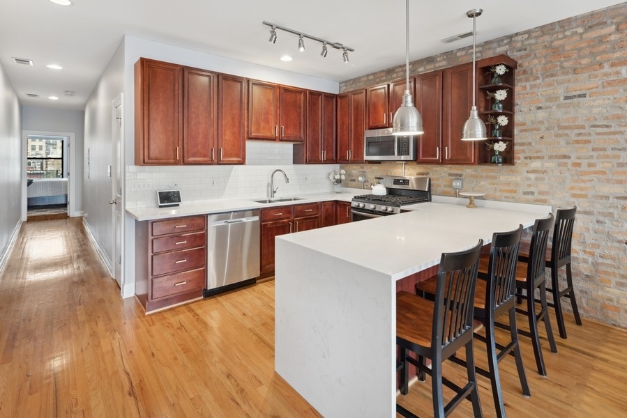 1025 West Madison Street, Unit 4 Chicago, IL 60607 - Photo 8 of 26 a kitchen with a sink a microwave and cabinets