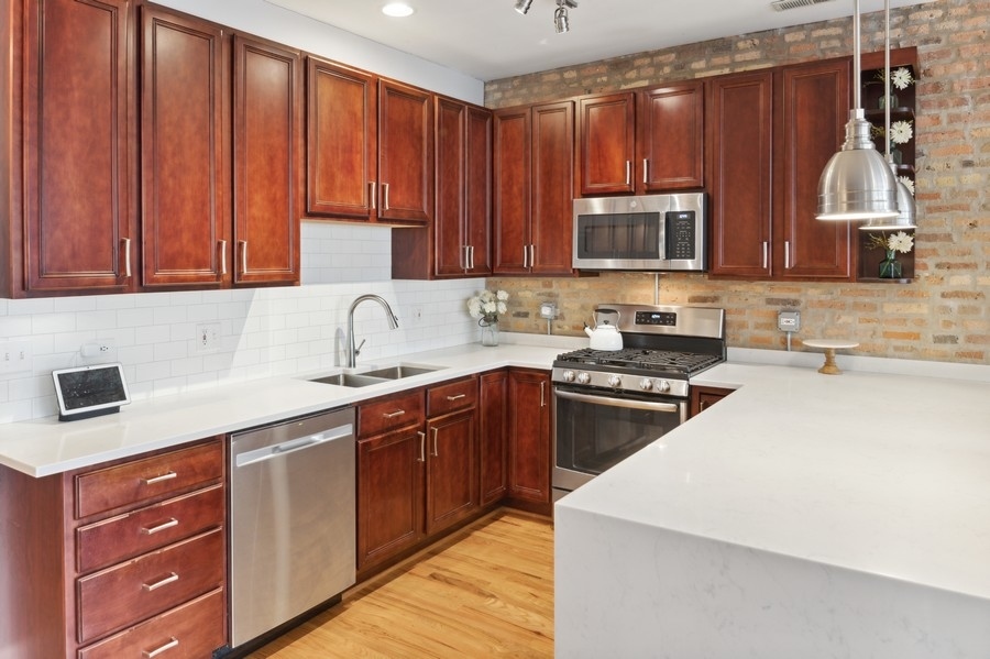 1025 West Madison Street, Unit 4 Chicago, IL 60607 - Photo 9 of 26 a kitchen with wooden cabinets and a sink