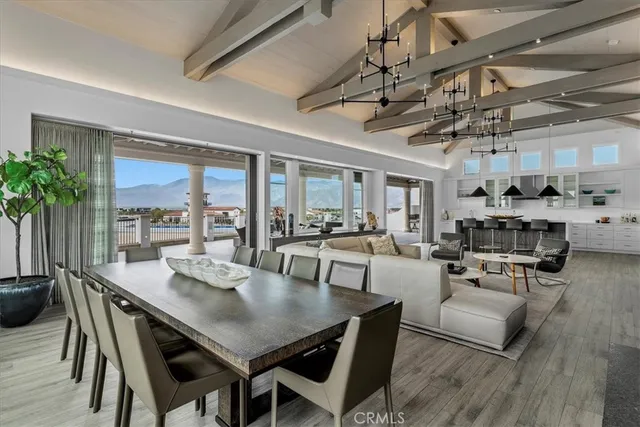 a kitchen with stainless steel appliances a dining table chairs and stove