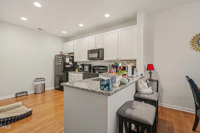 a kitchen with stainless steel appliances granite countertop a sink refrigerator and microwave
