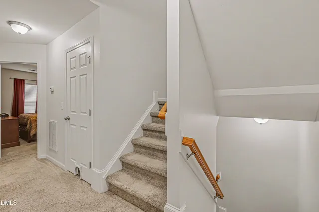 a view of staircase with white walls and railing