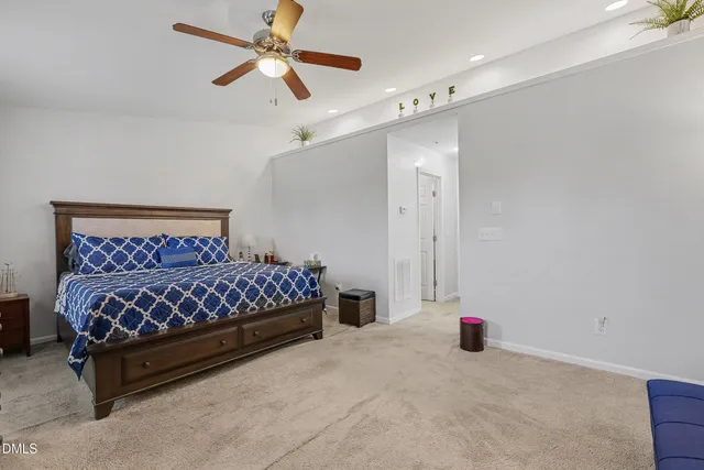 a bedroom with a bed and a chandelier fan