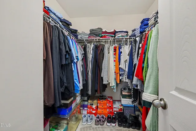 a view of walk in closet with clothes