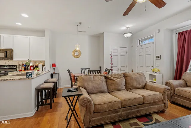 a living room with furniture a flat screen tv and kitchen view