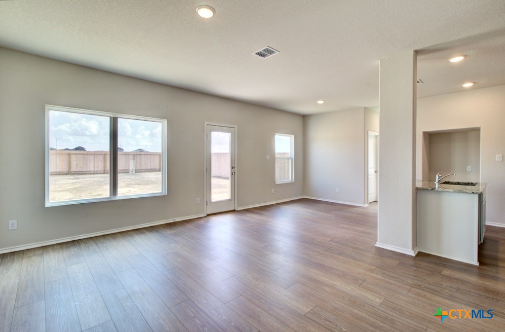 11242 Prairie Landing Converse, TX 78109 - Photo 6 of 24 an empty room with wooden floor and windows