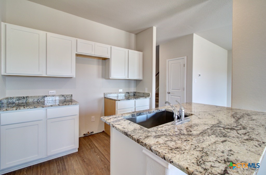 11242 Prairie Landing Converse, TX 78109 - Photo 10 of 24 a kitchen with granite countertop a sink a stove and cabinets