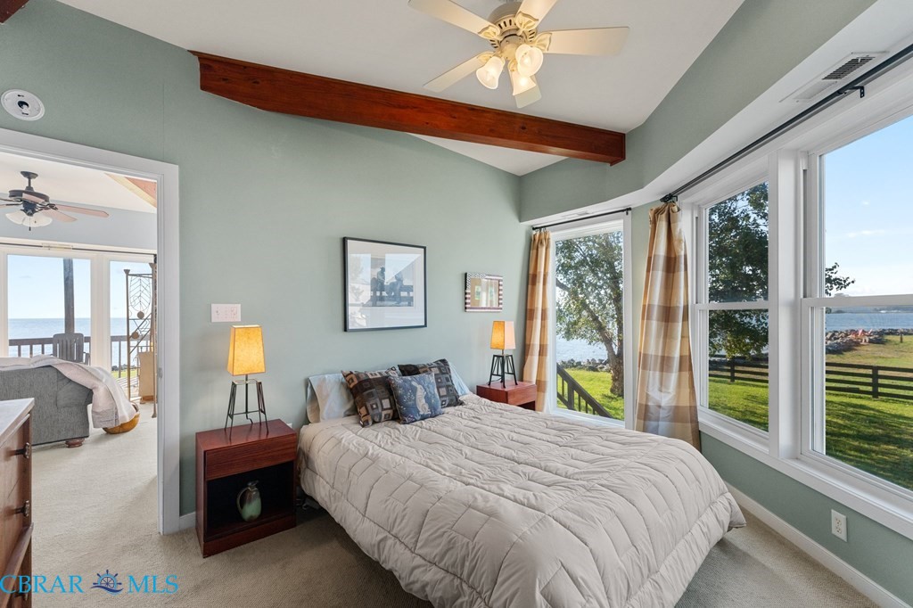 24 River Road Lottsburg, VA 22511 - Photo 18 of 35 a bedroom with a large bed and a chandelier