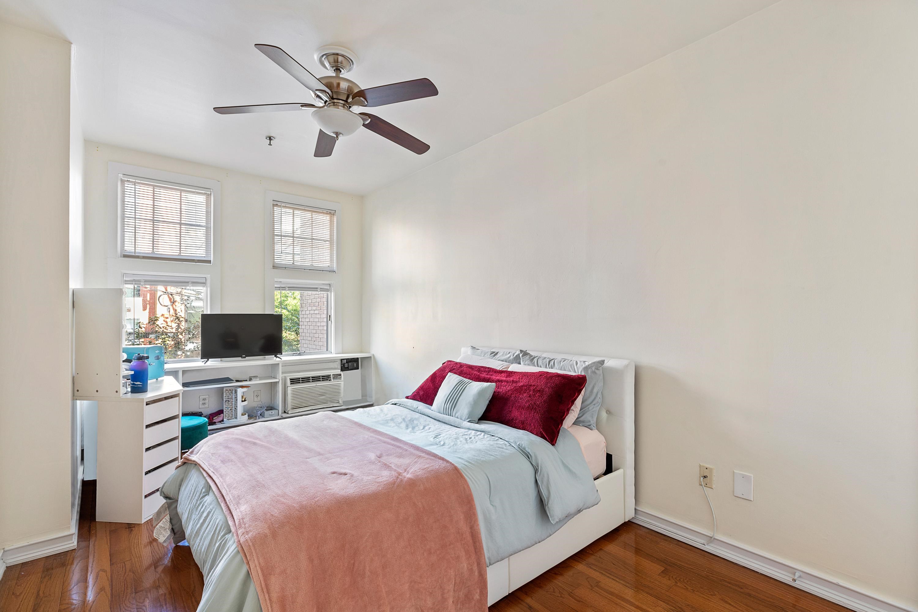 73 Madison Street, Unit 1N Hoboken, NJ 07030 - Photo 13 of 17 a bedroom with a bed and a flat screen tv