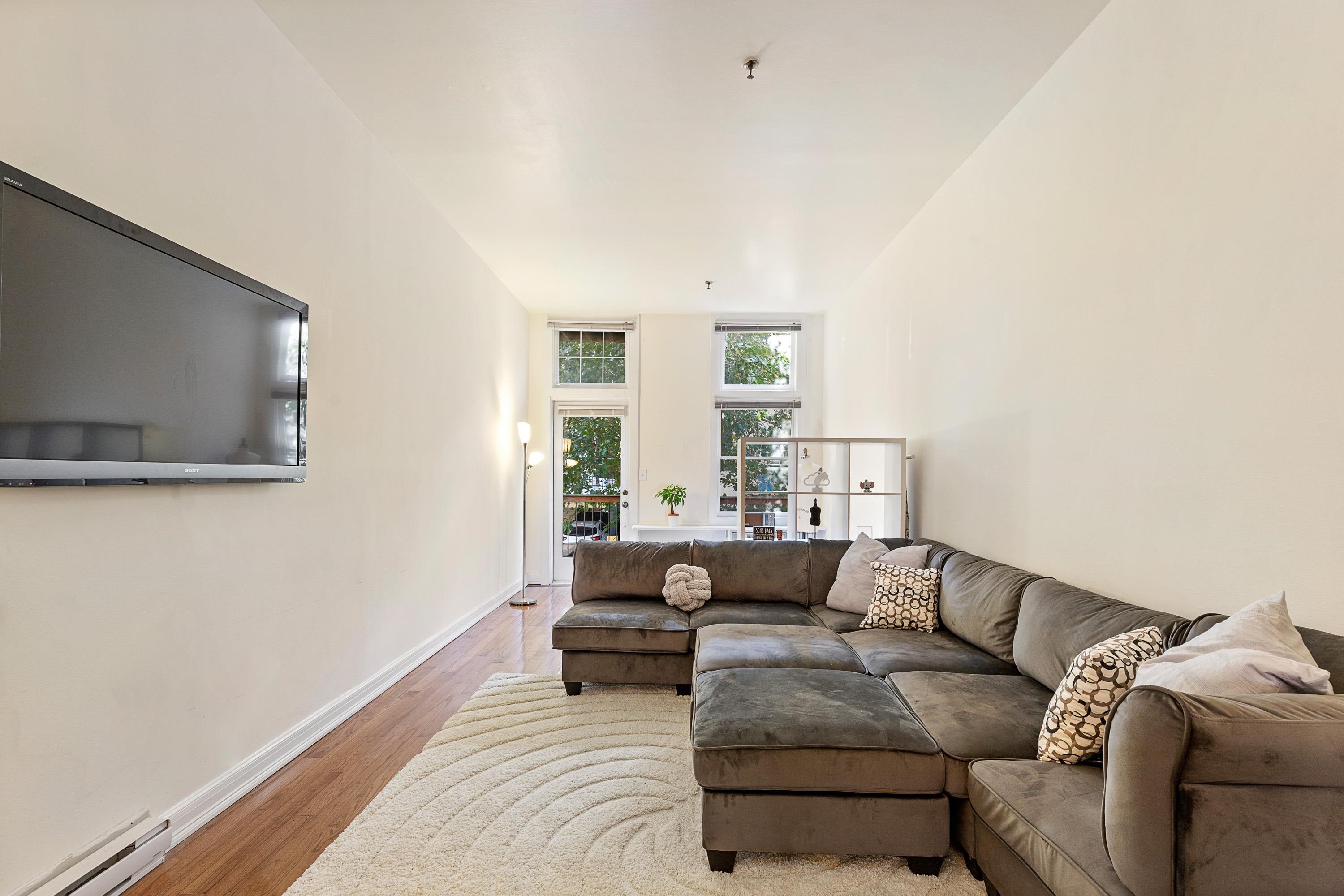 73 Madison Street, Unit 1N Hoboken, NJ 07030 - Photo 3 of 17 a living room with furniture and a flat screen tv