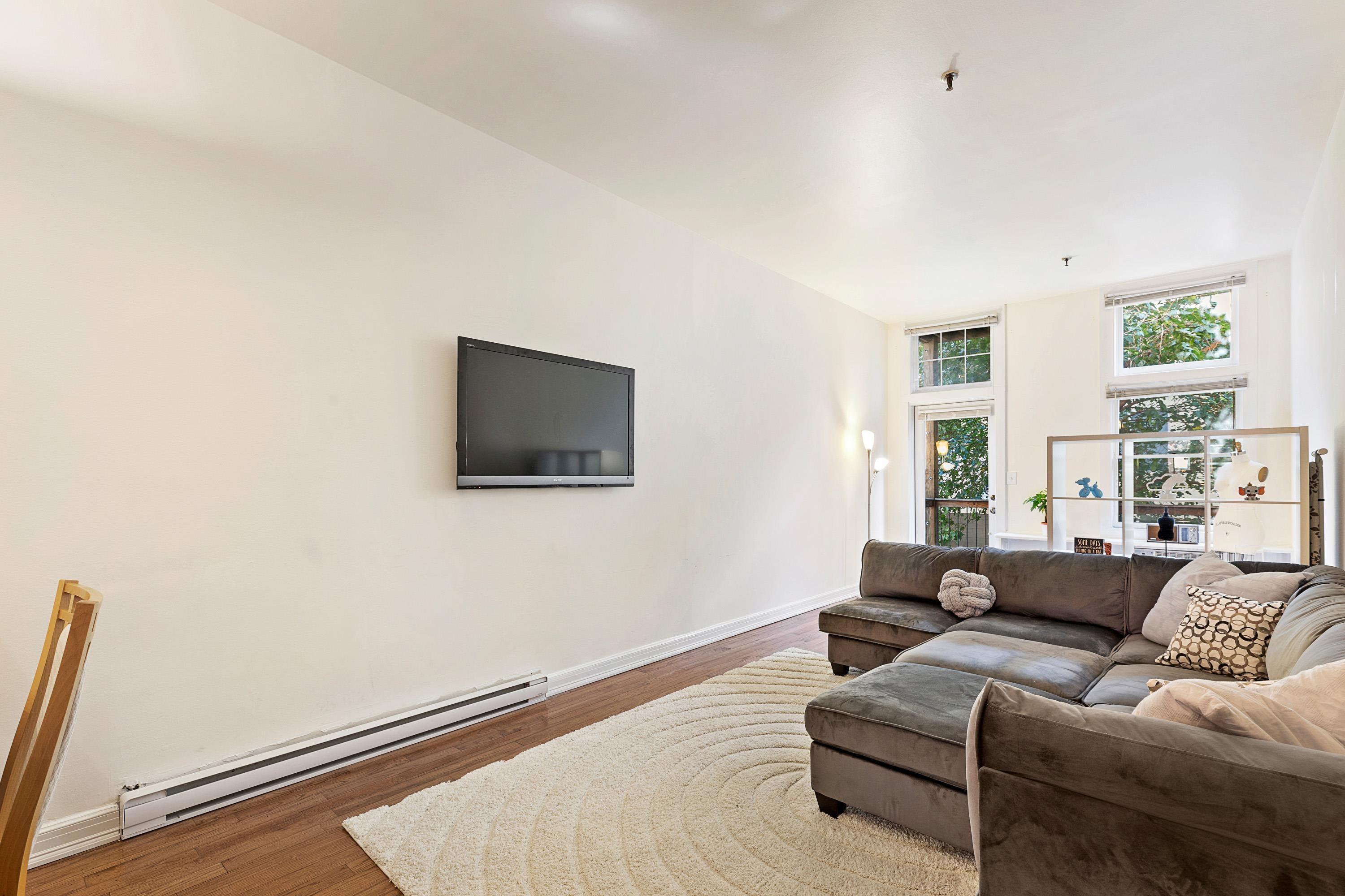 73 Madison Street, Unit 1N Hoboken, NJ 07030 - Photo 4 of 17 a living room with furniture and a flat screen tv
