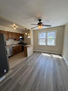 7007 Bank Street Baltimore, MD 21224 - Photo 5 of 17 a large kitchen with stainless steel appliances granite countertop a stove a refrigerator a sink and dishwasher with wooden floor