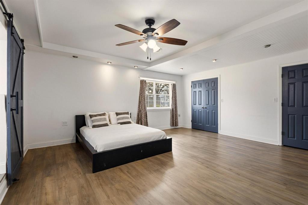 1053 Paradise Cove Road Pottsboro, TX 75076 - Photo 11 of 35 Bedroom with a barn door, dark wood finished floors, and ceiling fan