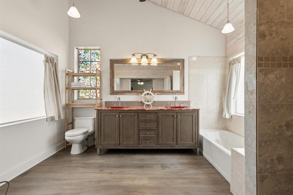 1053 Paradise Cove Road Pottsboro, TX 75076 - Photo 12 of 35 Primary ensuite bathroom featuring double vanity, light wood-type flooring, a bath, and vaulted ceiling