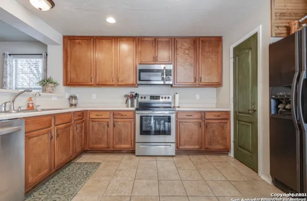 a kitchen with a refrigerator sink and cabinets