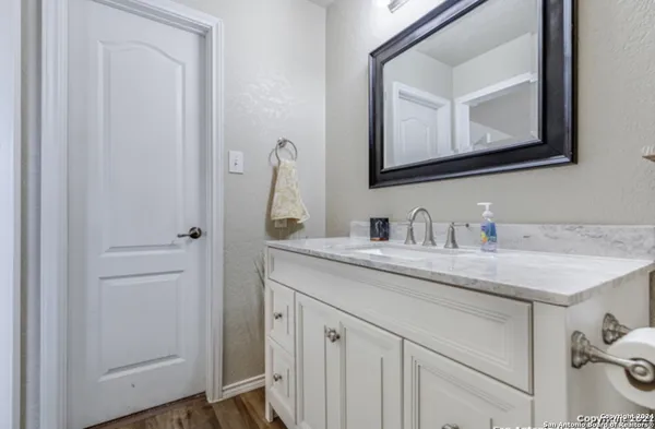 a bathroom with a granite countertop sink and a mirror