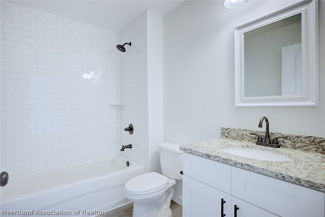 111 Vale Court Sebring, FL 33876 - Photo 27 of 40 a bathroom with a granite countertop sink a toilet and shower