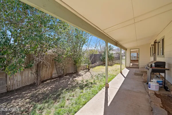 a view of a patio with a table and chairs next to a yard