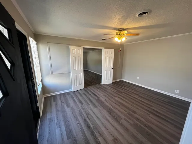 a view of empty room with wooden floor