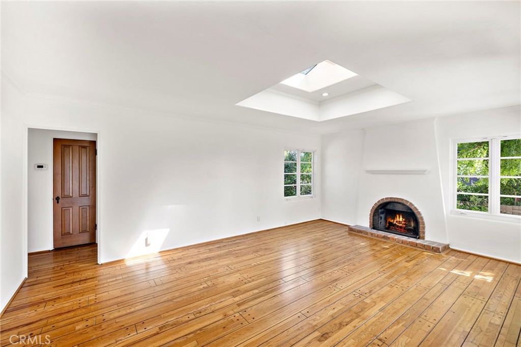 508 Seaview Street Laguna Beach, CA 92651 - Photo 6 of 28 an empty room with wooden floor fireplace and windows