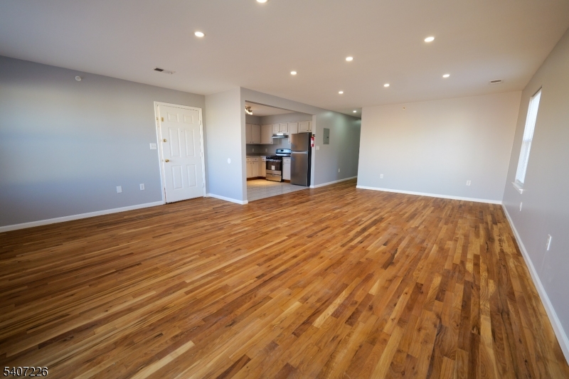 40 11th Avenue West, Unit 2 Newark, NJ 07107 - Photo 3 of 15 a view of empty room with wooden floor and fan