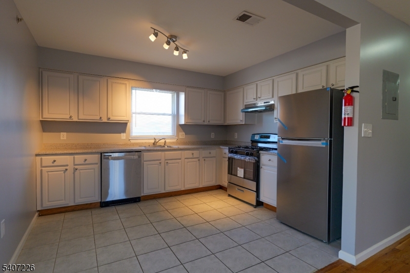 40 11th Avenue West, Unit 2 Newark, NJ 07107 - Photo 4 of 15 a kitchen with a refrigerator sink and cabinets