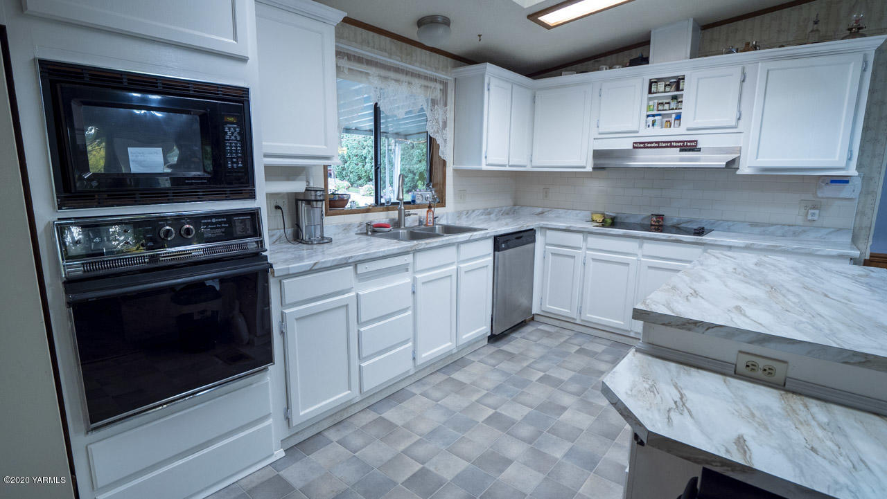 831 Swan Road Sunnyside, WA 98944 - Photo 13 of 19 a kitchen with stainless steel appliances granite countertop a stove and a microwave