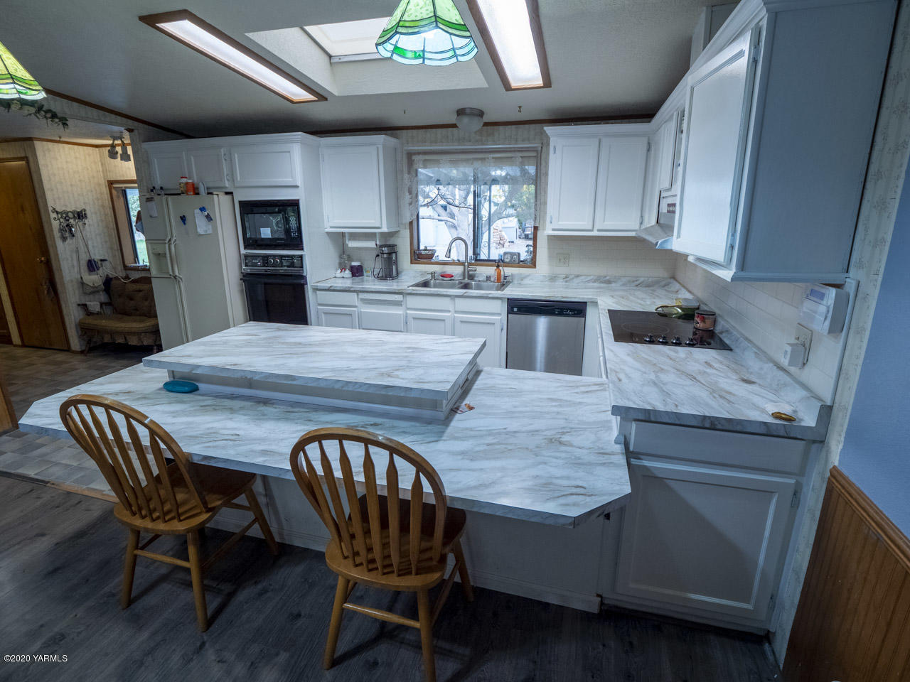 831 Swan Road Sunnyside, WA 98944 - Photo 15 of 19 a kitchen with stainless steel appliances granite countertop table chairs sink refrigerator and microwave