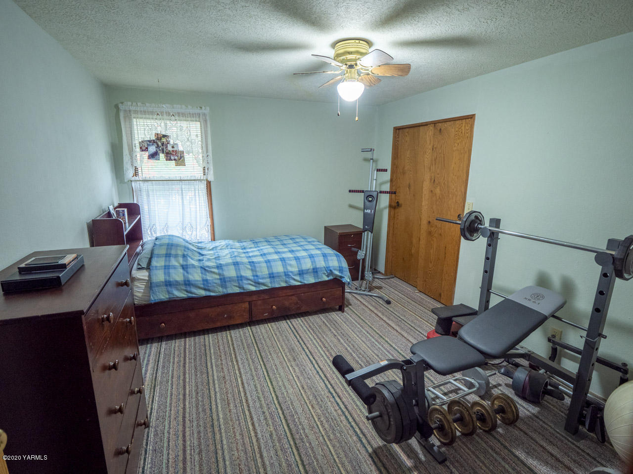 831 Swan Road Sunnyside, WA 98944 - Photo 5 of 19 a bedroom with a bed and wooden floor