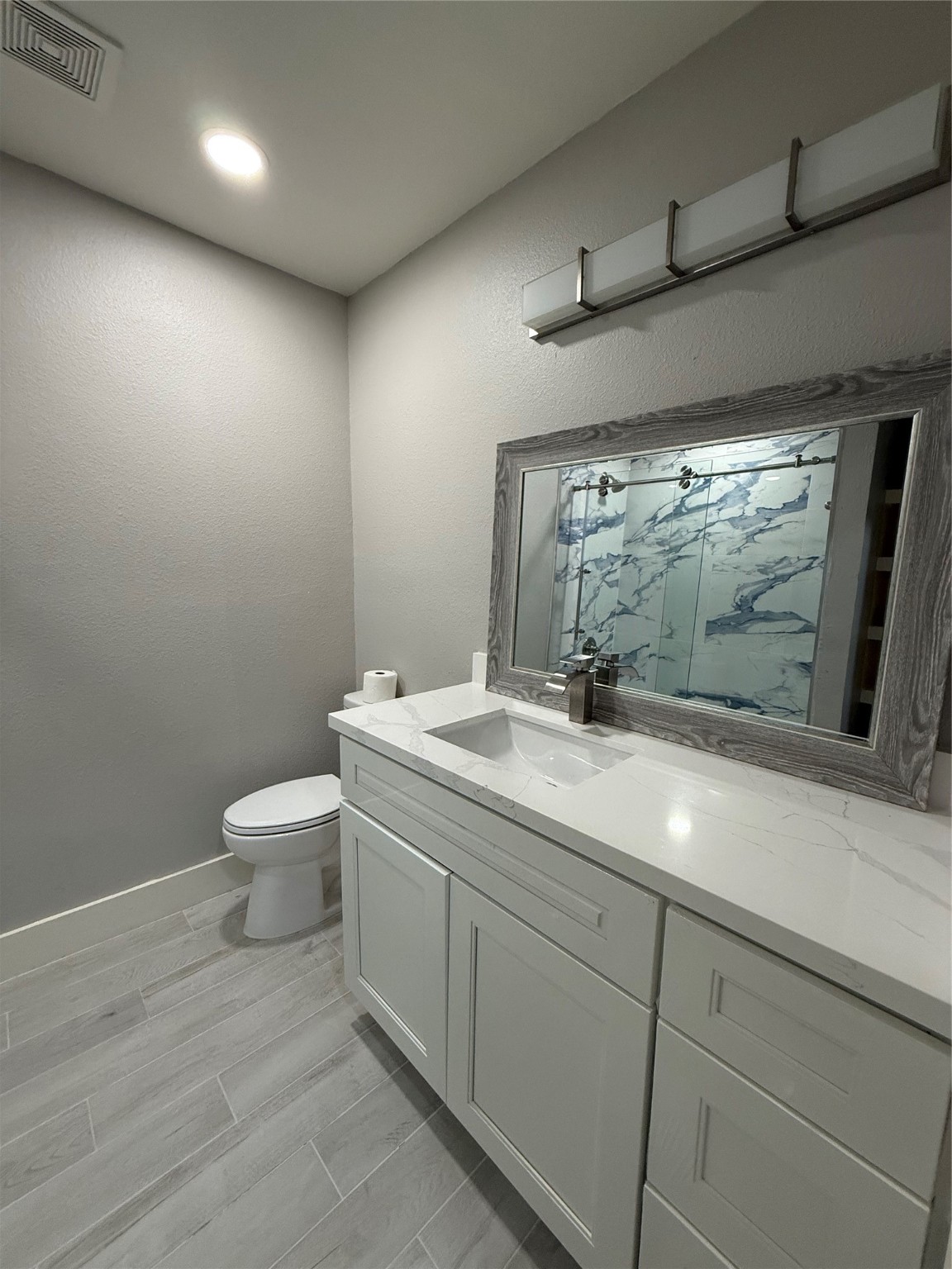 175 Heather Lane Livingston, TX 77351 - Photo 5 of 12 a bathroom with a granite countertop sink a toilet and a mirror