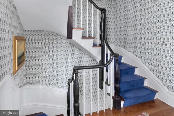 a view of staircase with wooden floor and white walls