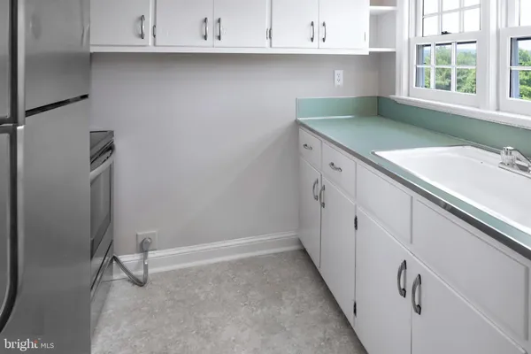 a kitchen with granite countertop a sink a stove and cabinets