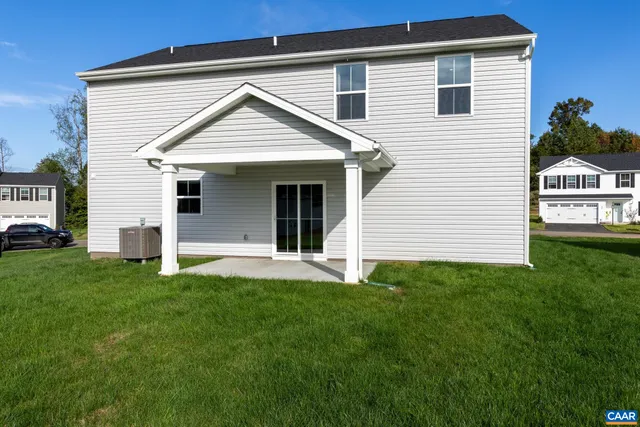 an aerial view of a house with a garden and lake view