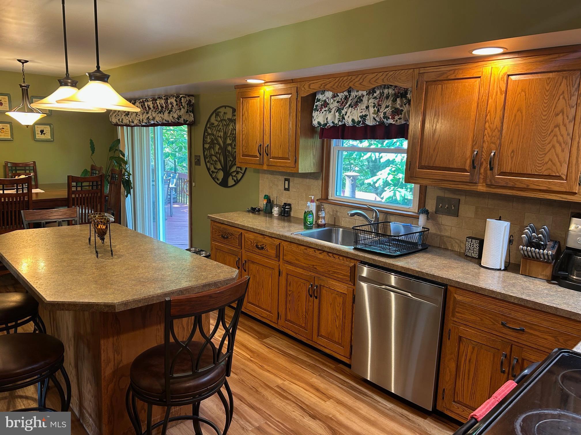 1008 Lincoln Avenue Springfield, PA 19064 - Photo 25 of 53 a kitchen with stainless steel appliances granite countertop a sink a microwave oven and a dining table with wooden floor