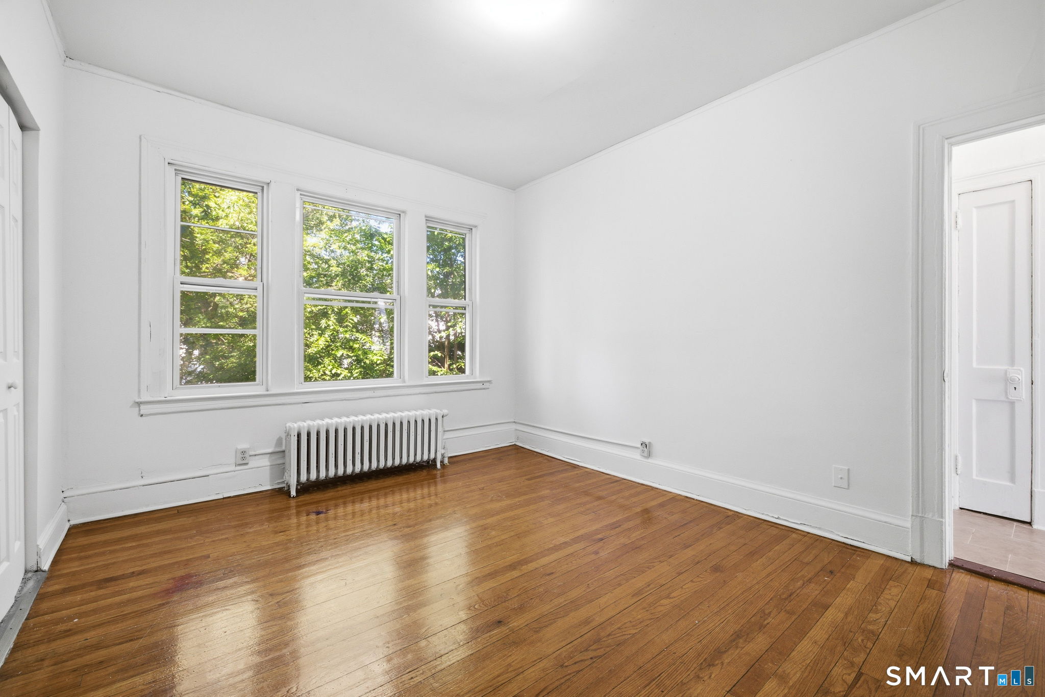 115 Baltimore Street, Unit 2 Hartford, CT 06112 - Photo 8 of 14 an empty room with wooden floor and windows