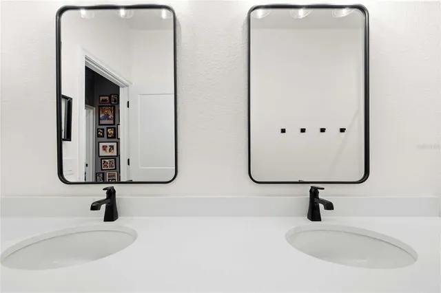 a bathroom with double vanity sink and a mirror