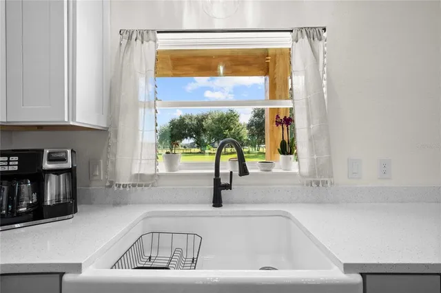 a kitchen with stainless steel appliances granite countertop a table chairs sink refrigerator and microwave