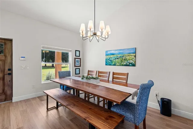 a view of a dining room with furniture wooden floor and a chandelier