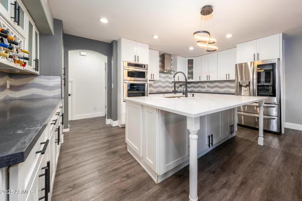 a large kitchen with a large counter top appliances and cabinets