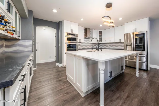 a large kitchen with a large counter top appliances and cabinets