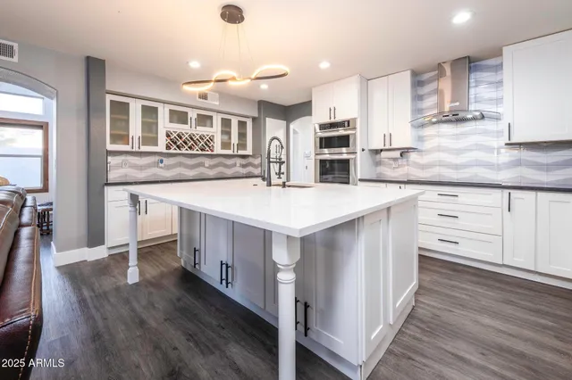 a kitchen with kitchen island a stove a sink and a refrigerator