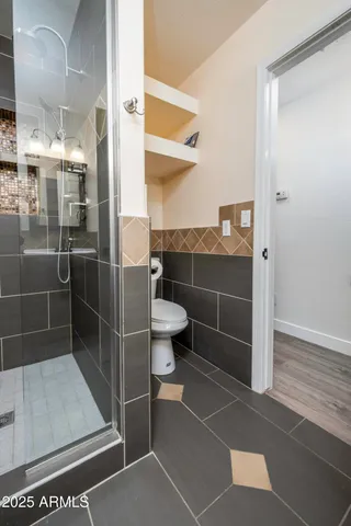a bathroom with a toilet and a shower