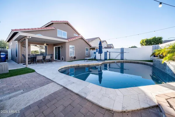 a view of a house with swimming pool and sitting area