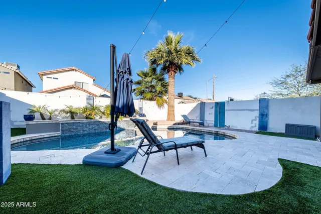 a swimming pool with outdoor seating and garden