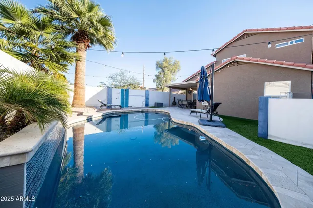 a view of a house with pool and sitting area