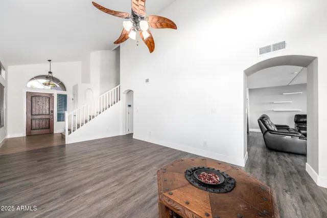 a view of a livingroom with furniture wooden floor chandelier and a chandelier fan